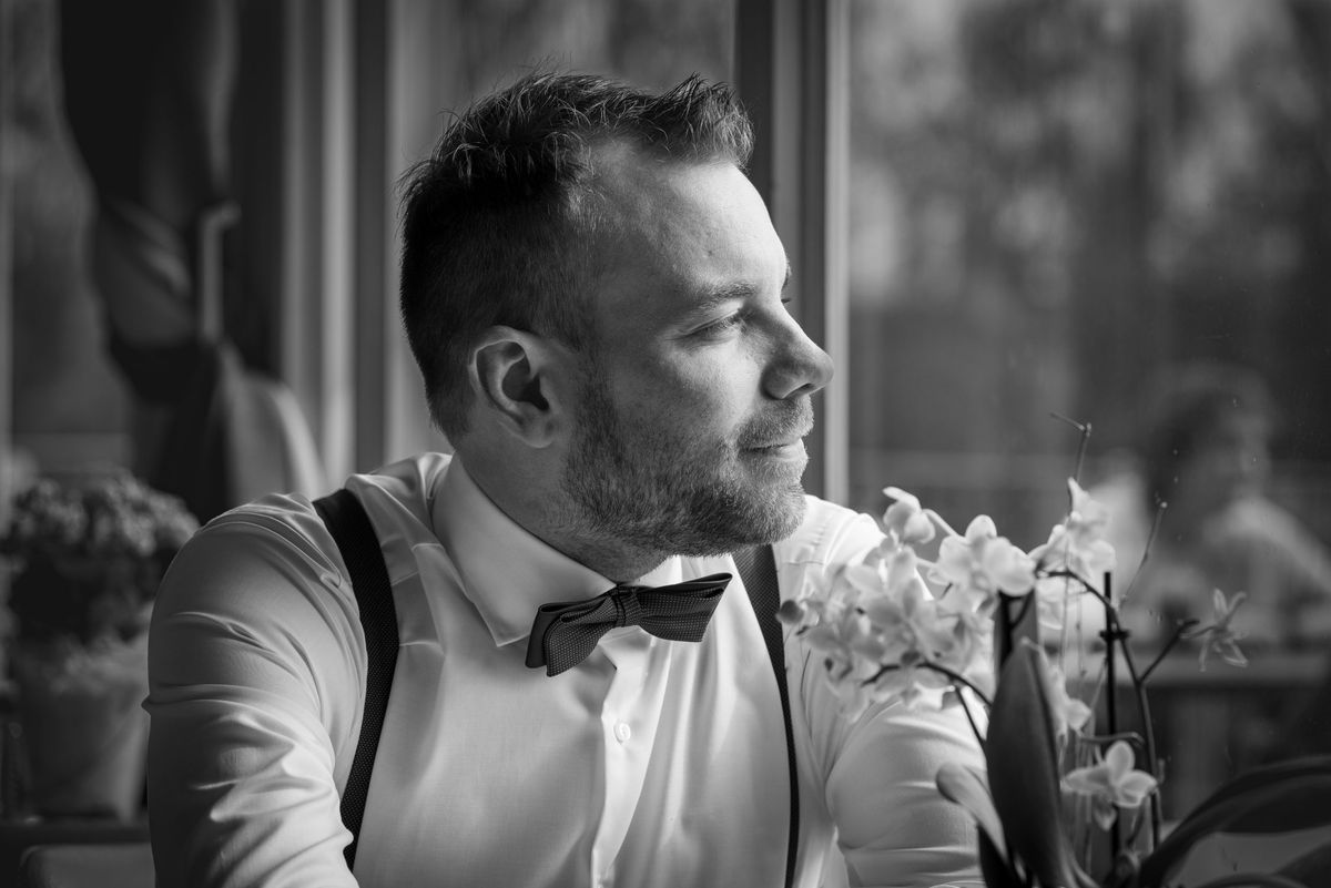 Schwarzweiß-Porträt eines Mannes im Anzug mit Blumen